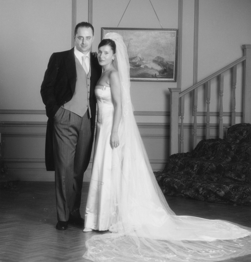 Groom and bride wearing strapless wedding gown with train