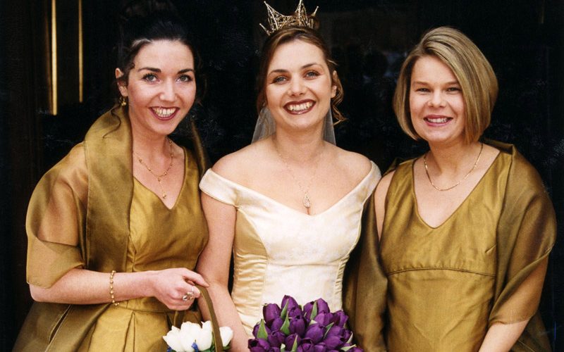 Bride wearing fitted bodice gown and bridesmaids in antique gold bespoke gowns at wedding